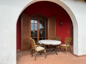 Aci CatenaにあるTerra Maison de Charme Siciliaの赤い壁のパティオ(テーブル、椅子付)