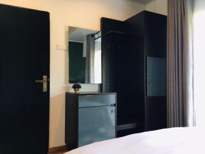 a bedroom with a bed and a dresser and a mirror at The Greens Luxury Apartment in Nuwara Eliya