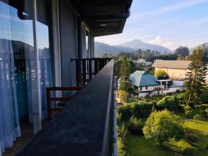 a balcony with a view of a house at The Greens Luxury Apartment in Nuwara Eliya