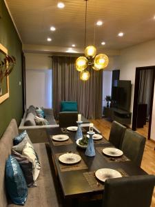 un soggiorno con tavolo e divano di The Greens Luxury Apartment a Nuwara Eliya