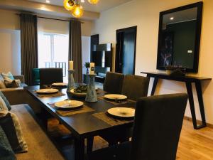 a living room with a dining room table and chairs at The Greens Luxury Apartment in Nuwara Eliya