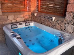 a jacuzzi tub in a room with a stone wall at Petromilos1920 in Zefiría
