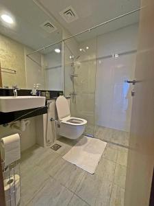 y baño con aseo, lavabo y ducha. en Dubai Canal Burj khalifa view 2bedroom apartment, en Al Ḩamīdīyah