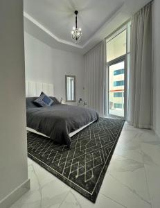 a bedroom with a bed and a large window at Dubai Canal Burj khalifa view 2bedroom apartment in Al Ḩamīdīyah
