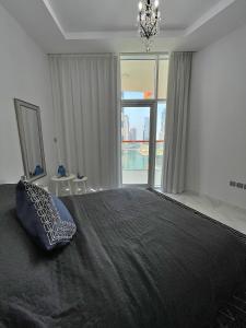 a bedroom with a large bed and a large window at Dubai Canal Burj khalifa view 2bedroom apartment in Al Ḩamīdīyah