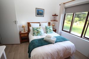 a bedroom with a large bed with a window at Deo-Lize in Bettyʼs Bay