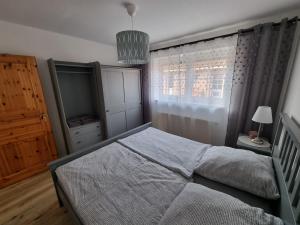 Schlafzimmer mit einem Bett und einem Fenster in der Unterkunft Ferienwohnung Nordseemond in Norden