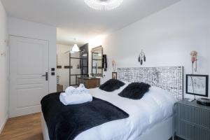 a bedroom with a white bed with two towels on it at Le Globe-Trotter - Proche du metro gare de Vaise in Lyon
