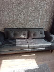 ein Ledersofa im Wohnzimmer mit einer Wand in der Unterkunft Konyaaltı Tunç Apart in Antalya