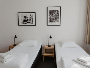 due letti in una stanza con pareti bianche di Norrland YMCA Hostel Umeå a Umeå