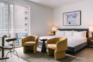 ein Hotelzimmer mit einem Bett und zwei Stühlen in der Unterkunft Sonder Midtown South in Atlanta