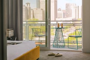 a hotel room with a bed and a balcony with chairs at Sonder Midtown South in Atlanta