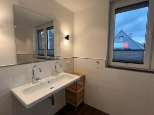 baño con lavabo y ventana en Astrid's Appartements, en Winterberg