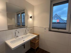 a bathroom with a sink and a window at Astrid's Appartements in Winterberg +83 photos