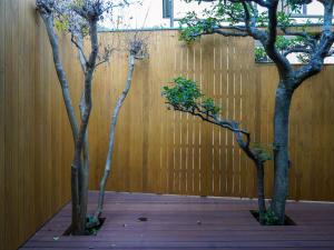 dos árboles frente a una valla de madera en Gyokusenkaku, en Nagato