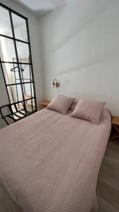 a bedroom with a large bed with a window at Hotel Restaurant Les Paquebots in Port-Vendres