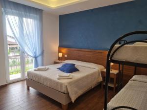 a bedroom with two beds and a large window at Stella Marina Paestum in Capaccio-Paestum