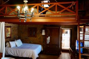 a bedroom with a loft bed with a chandelier at Montsant in Teror