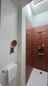 y baño con ducha de azulejos marrones. en Hotel Restaurant Les Paquebots, en Port-Vendres