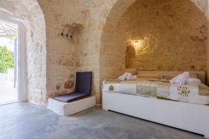 um quarto com uma cama e uma cadeira em Villa Stellina and Trullo Cecé em Ostuni