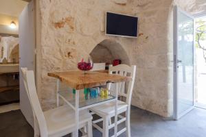 uma sala de jantar com mesa e cadeiras e uma parede de pedra em Villa Stellina and Trullo Cecé em Ostuni