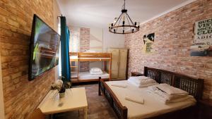 a room with two beds in a room with a brick wall at Hostel Chmielna 5 Rooms & Apartments in Warsaw