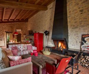 sala de estar con sofá y chimenea en Els Masos de Caula en Girona