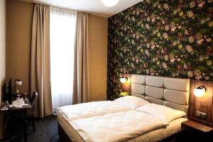 1 dormitorio con una gran pared floral sobre una cama en EA Hotel Victoria en Praga