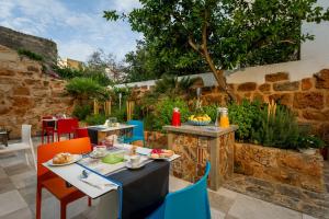 a patio with a table and chairs in a garden at Hotel Vento del Sud in San Vito lo Capo
