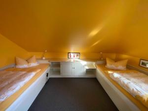 Duas camas num quarto com paredes amarelas em Appartementhaus Grieger em Bad Bevensen