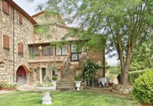 une maison en pierre avec un escalier dans la cour dans l'établissement Il Casale La Duchessa, à Vetulonia