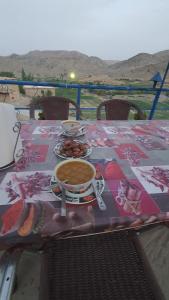 einen Tisch mit einer Tasse Kaffee und Teller mit Speisen in der Unterkunft Auberge Jbel Raids in Tagoudit