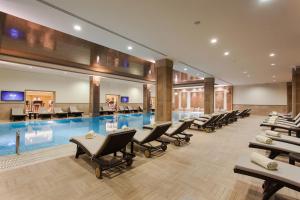 a pool with lounge chairs and a swimming pool at Divan Erbil Hotel in Erbil