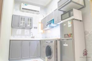 una piccola cucina con frigorifero e lavandino di فندق صحارى الفرسان a Şabyā