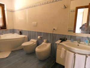 a bathroom with a tub and a toilet and a sink at Villa Magnolia B&B in Taormina