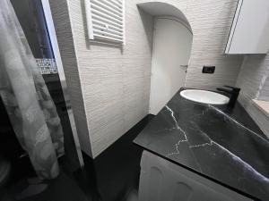 een badkamer met een wastafel en een zwart aanrecht bij Casa vacanze la volta in Rodi Garganico