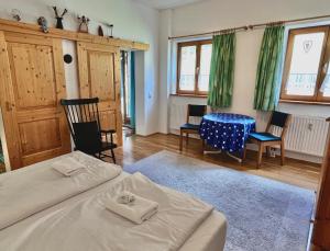 a bedroom with a bed and a table and chairs at Ferienwohnung Spitzingsattel im Wanderparadies in Spitzingsee