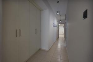 um corredor vazio com paredes brancas e pisos em azulejo em Aleksa Central by Estia em Heraclião