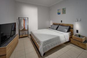 um quarto com uma cama e uma televisão de ecrã plano em Aleksa Central by Estia em Heraclião