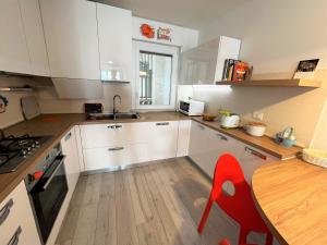 a kitchen with white cabinets and a wooden table and a tableablish at Nettuno in Grado
