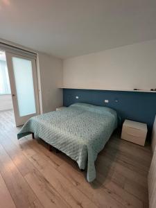 een slaapkamer met een bed met een blauwe muur bij Nettuno in Grado