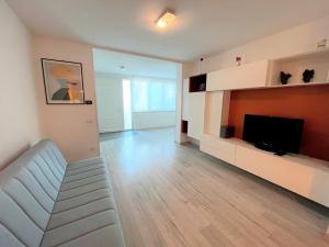 een woonkamer met een bank en een flatscreen-tv bij Nettuno in Grado