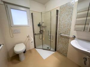a bathroom with a shower and a toilet and a sink at Nettuno in Grado +9 photos