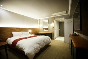 a hotel room with a large bed and a bathroom at Ariana Hotel in Daegu