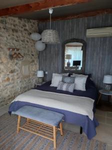 a bedroom with a large bed and a mirror at mas de manon in Valréas