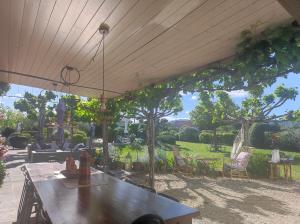 a patio with a table and chairs and a tree at mas de manon in Valréas