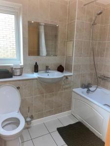 a bathroom with a toilet and a sink at Easy Stay London - Bright and airy 2Bed Apart in London
