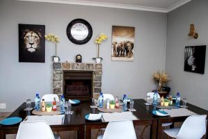 een eetkamer met een tafel en stoelen en een open haard bij Boutique Hotel on the Bay in Humewood