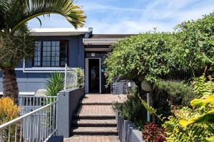 een huis met een trap die naar de voordeur leidt bij Boutique Hotel on the Bay in Humewood