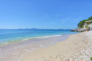 a beach with a rocky shore and the ocean at Kaminaki Beachfront Apartments in Nisaki